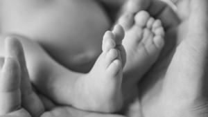 105234606-baby-feet-close-up-on-white-and-black-background.jpg
